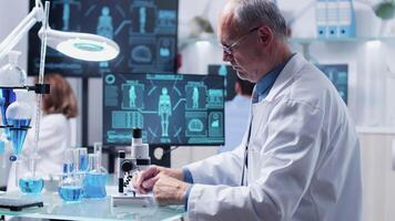 Chemist looking at a red sample in modern equipped laboratory video