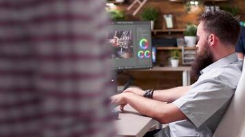 Videographer working in busy office, puts his headphones on video