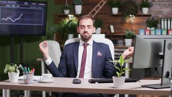 après une stressant, longue jour, homme d'affaire médite seul dans le bureau. confortable et agréable à la recherche lieu de travail video