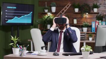 Businessman puts a VR headset and tries virtual reality for the first time. He is alone in the office video