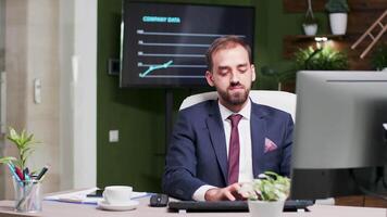 Office worker in suit types on computer keyboard, then looks at the time, realizing he is late video