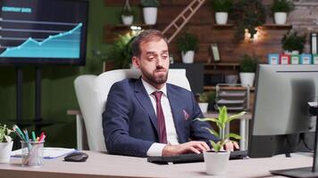 Exhausted office worker yawning while typing on the computer in modern and nice looking work space video