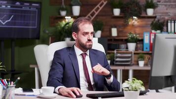 Businessman reading an important email, happily reacts. in the background - modern office with creative design and screens displaying animated charts and data. Slow motion footage video