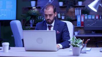 Slow motion shot of happy businessman rising his hands up. Late night in the office. Blue moon light video