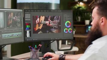 schermen van professioneel video editor en colorist werken Aan musical klem in modern ontwerp studio type kantoor