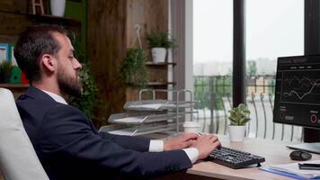 homme d'affaire dans moderne Bureau avec gros les fenêtres travail sur le ordinateur. lent mouvement métrage video