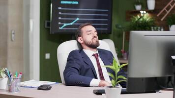 cansado empresario cayó dormido a su lugar de trabajo. él es solo en el oficina video