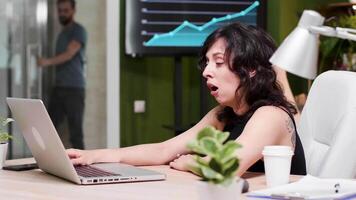 fêmea corporativo trabalhador é cansado às dela ambiente de trabalho. ela bocejos enquanto uma homem é entrando a escritório porta video