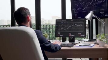 Zooming in on the monitor screen displaying sales statistics. Modern office with big windows. Slow motion footage video