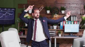 Slow motion handheld shot of corporate office worker dancing while nobody else is watching video