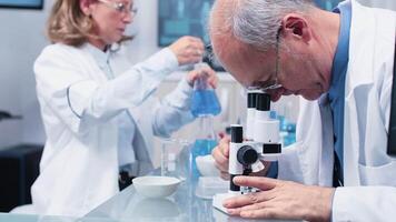 Close up shot of scientists working in busy modern laboratory video