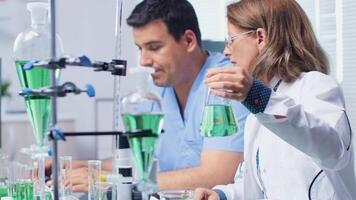 Female laboratory engineer working with her assistant in modern and high end biochemistry lab video