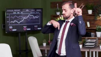 Slow motion handheld shot of businessman dancing alone in the office video