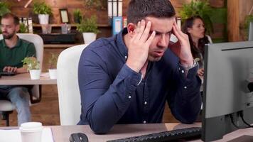 retrato de estresado y sobrecargado de trabajo empleado molesto a trabajo en un ocupado oficina video