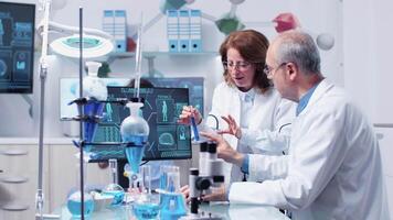 Male and female researcher are debating over a sample in modern science center video