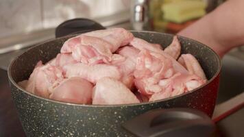 lavaggio il fritte pollo e collocazione esso su un' pentola. crudo pezzi di pollo su un' pentola. cucinando concetto. preparazione per cucinare. video