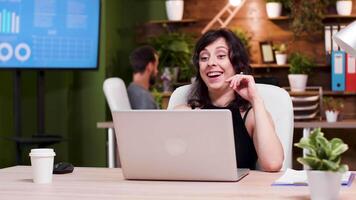 Office worker reads some good news on the laptop. She is very happy. Slow motion shot video