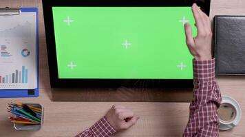 Top view of man's hands scrolling over the left edge of a green screen touch monitor. Office and corporate concept. Big chroma key. video