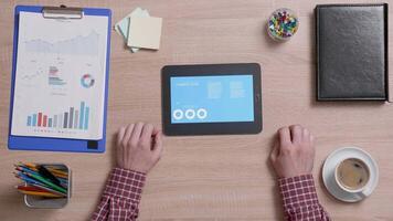 Above shot of a man using a data analysys application on his tablet. Office and corporate concept. Company data verify. video