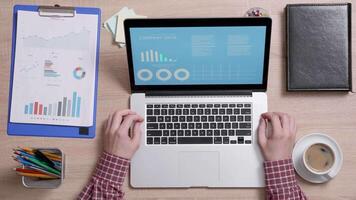 Top view of a financial advisor's desk analyzing data on a laptop. Office work concept. Man working on company data optimization. video