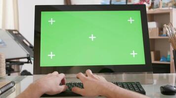 Young artists hands typing a text on the keyboard in front of a green screen. Artistic environment concept. video