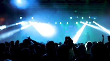 People at a rock concert dancing in front of the stage. Rock band performing on the stage in front of fans. video