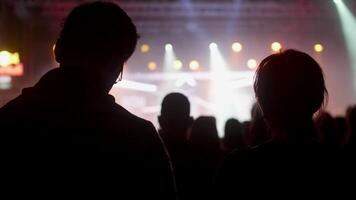 giovane uomo e donna a un' musica Festival godendo il prestazione. un' coppia di giovane persone a un' roccia concerto. video