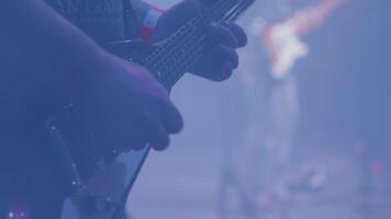 Masculin musicien mains pièces à une guitare dans de face de une foule à une Roche concert. musicien avec un électrique guitare à une la musique festival. video