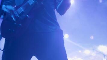 Male musician rocks at the guitar in front of a crowd at a rock concert. Musician with an electric guitar at a music festival. video