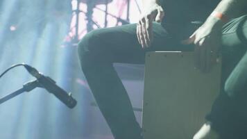 homme tambouriner rythme à une cajon pendant une performance sur organiser. percussionniste performant à une la musique festival. video