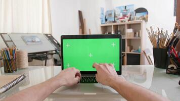 designers punkt av se arbetssätt på en bärbar dator med grön skärm på. målare verkstad. konstnärlig begrepp. krom nyckel. video