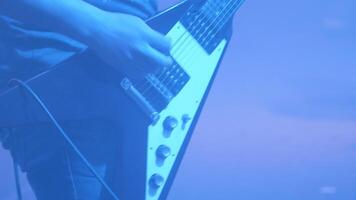 guitare joueur performant dans de face de une foule à une Roche concert. musicien avec un électrique guitare à une la musique festival. video