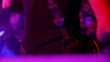 Shot from behind a guitar player performing in front of an audience. Guitarist rocking at a music event. video