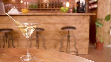 Slow sliding shot of a glass of martini in an empty restaurant. A glass of alcoholic beverage on an empty bar table. video