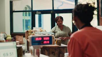 Customer checking organic bio merchandise in grocery store, looking for additives free pasta or pantry items to buy weekly supplies. African american woman searching for nonpolluting goods. video