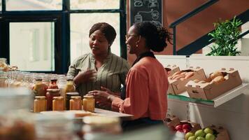 local magasinier recommande céréales et fait maison sauces à fidèle client, assurer biologique la source de protéines pour des biens dans bocaux. marchande en présentant Nouveau écologique non polluant marchandise. video