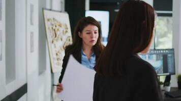 Anfang Mannschaft Arbeiten mit architektonisch Entwurf Pläne, studieren Rahmen Messungen und technisch Elemente im Coworking Raum. Frau Architekten suchen beim 3d maquette Gebäude Modell. video