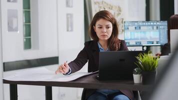 architect aan het studeren eigendom lay-out Aan laptop naar creëren blauwdruk, werken Aan verbouwing project Bij echt landgoed agentschap kantoor. deskundige ontwikkelen droogte met balans en metingen naar verbouwen ruimte. video