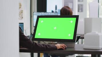 Cad specialist using computer with greenscreen at office desk, reviewing pc display with isolated copyspace layout in unicorn business coworking space. Architect blank chromakey template on monitor. video