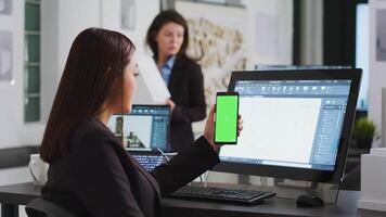 Engineer showing phone with greenscreen template on display, working at a architectural agency office. CAD expert using isolated chromakey layout on copyspace screen, mockup concept. video