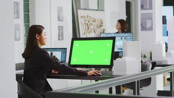 Architekt mit Computer mit grüner Bildschirm beim Arbeitsplatz im Agentur Büro, suchen beim leer Attrappe, Lehrmodell, Simulation Vorlage auf Monitor. Ingenieur beschäftigt beim ein echt Nachlass klein Geschäft. Stativ Schuss. video