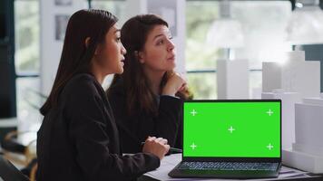 Team of engineers working with greenscreen display on pc, planning new building project with isolated copyspace layout on laptop. Architects using 3d building model and mockup chromakey. video