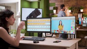 Female photographer working in professional editing software in creative media agency office. Over the shoulder shot video