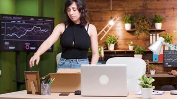 magnifique femme avoir mis à la porte de le emploi. elle packs sa affaires dans une papier carton boîte et feuilles le Bureau video