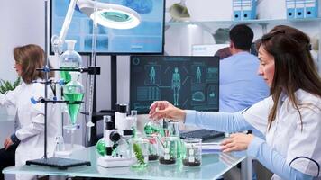 Zoom in shot of female scientist working in modern research center looking at test samples video