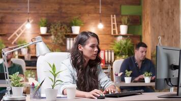 kvinna arbetstagare frågar hjälp från en kollega. de prata handla om en ny projekt och punkt på de dator skärm video