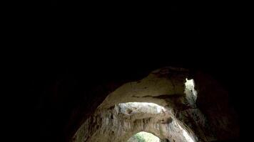 Panning down shot of big cave in the mountains. Travel and nature video