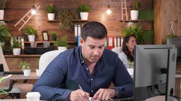 masculino escritório trabalhador levando notas dentro uma ocupado dia às a trabalhar. lento movimento ampliação dentro tiro video