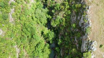 Aerial drone top down footage of canyon with a river and waterfalls in the mountains video