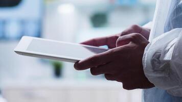 Close-up shot of researcher using a digital tablet PC in high-end lab video